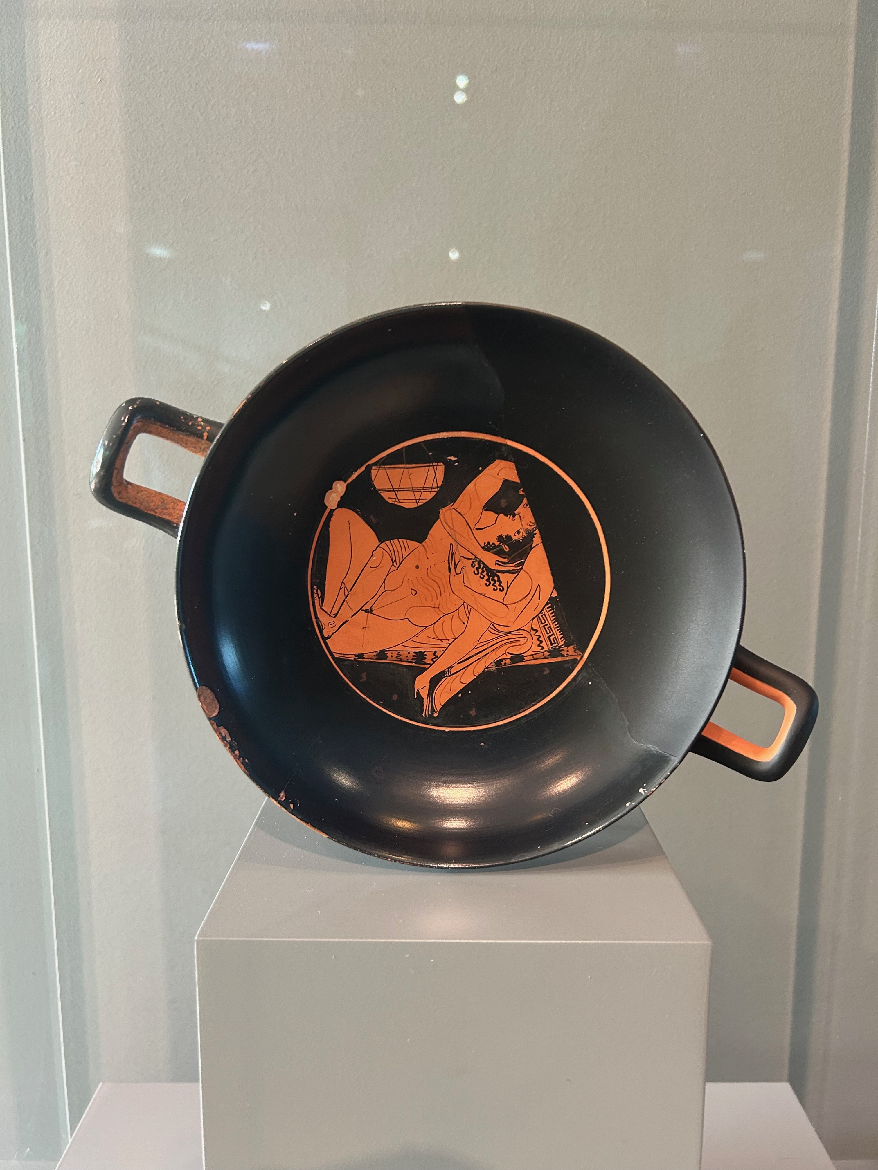 A Greek drinking bowl depicting lovers in an erotic embrace