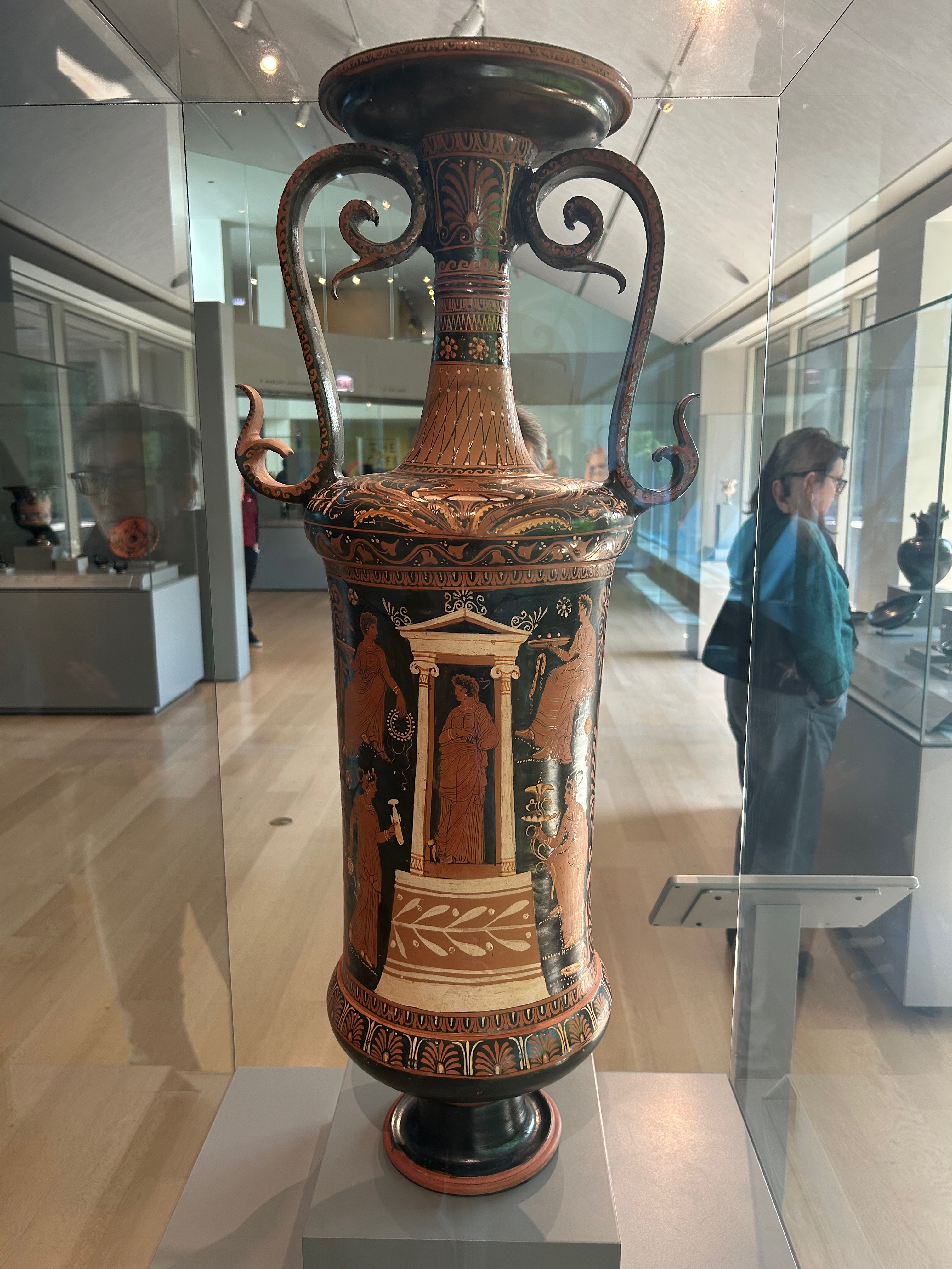 A tall jar intended to hold ritual bath water. On its side, a young woman is depicted within a shrine.