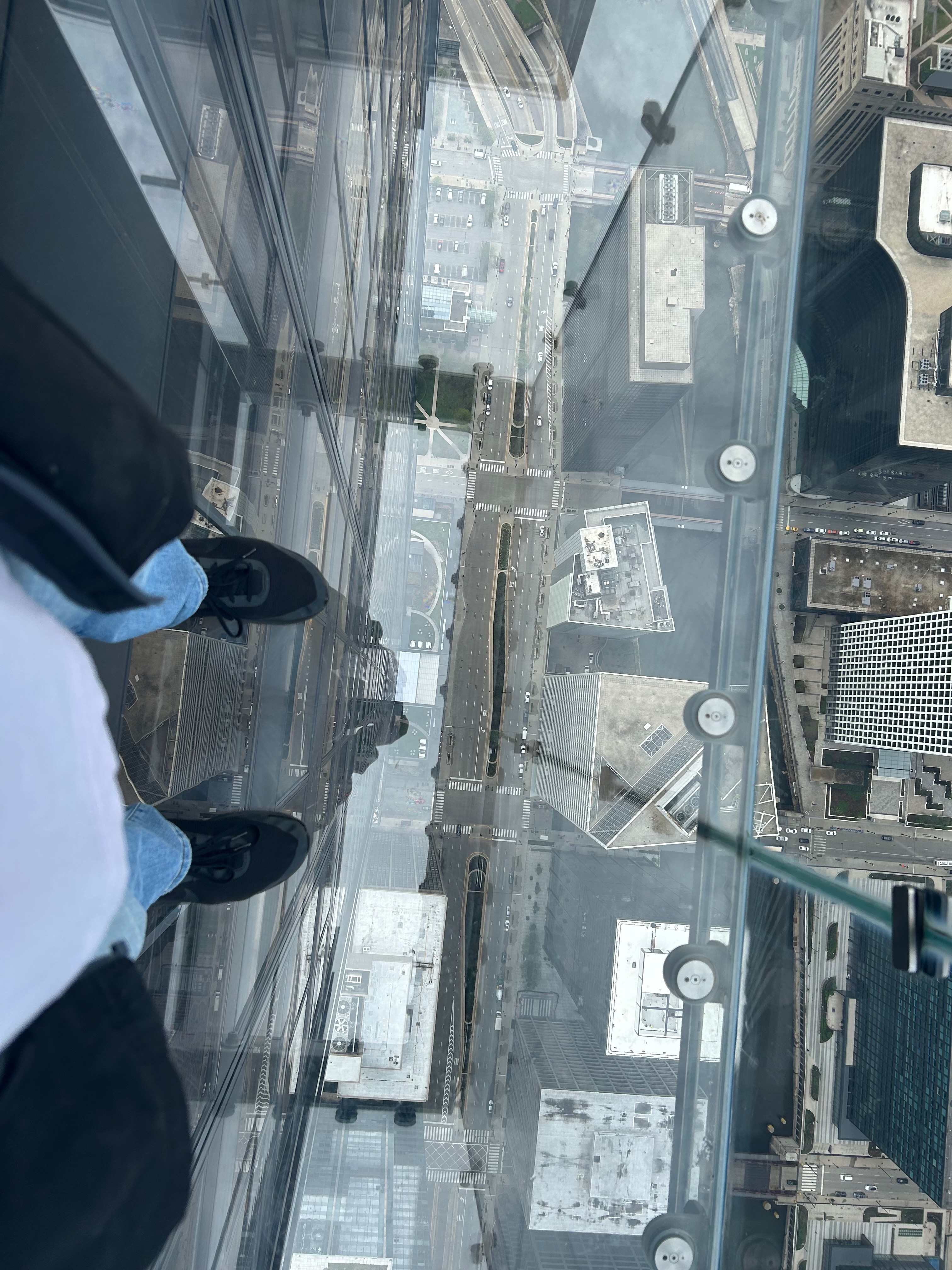 Looking through the glass ledge hanging over the edge of Willis Tower&rsquo;s observation deck